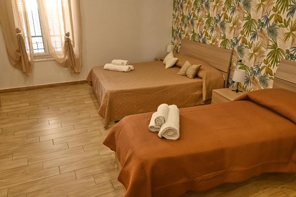 a hotel room with two beds with towels on them at Maison centro storico in Naples