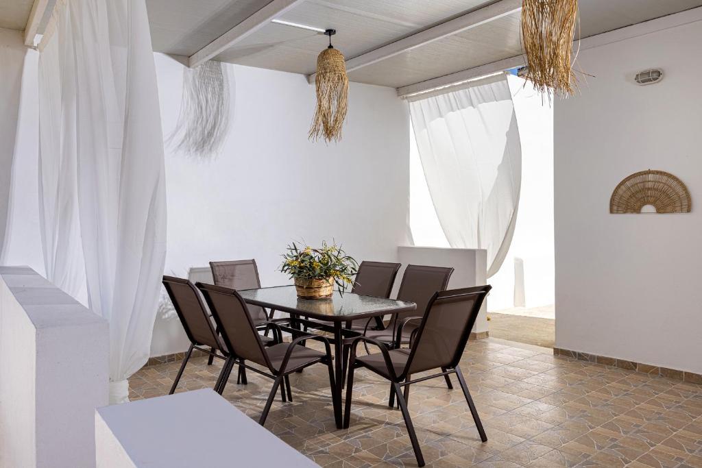 ein Esszimmer mit einem schwarzen Tisch und Stühlen in der Unterkunft Salty Beach Cottage, 20m from Kini Beach in Ano Syros