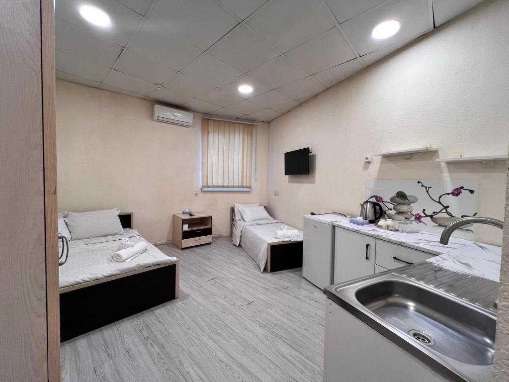 Habitación hospitalaria con 2 camas y lavamanos en Highland Holiday Home Hostel, en Ereván