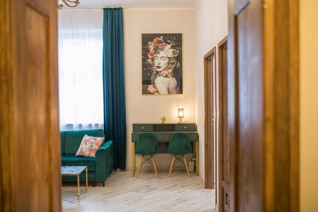 Una sala de estar con un sofá verde y una mesa. en Apartament Piastowski, en Polanica-Zdrój