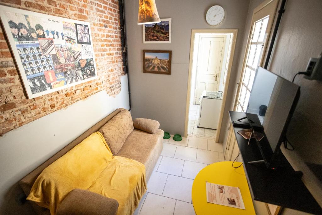 a living room with a couch and a brick wall at Apartamento central com pátio, 1 quadra do calçadão in Santa Maria
