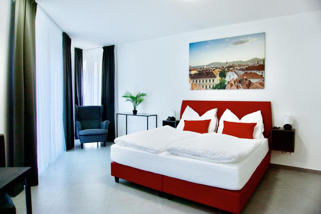 a bedroom with a red and white bed and a chair at Grazora Living Apartments in Graz
