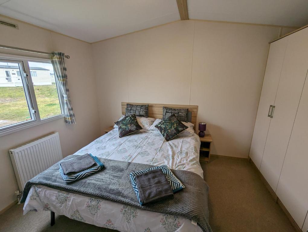 a bedroom with a bed and a window at D11 - the Dunes at Silver Sands in Lossiemouth