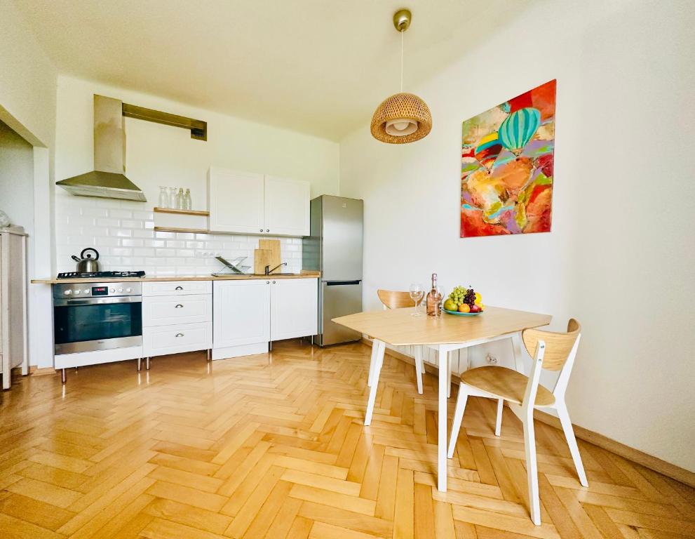 a kitchen with a wooden table and a dining room at Green&Comfy Apartment Żoliborz in Warsaw
