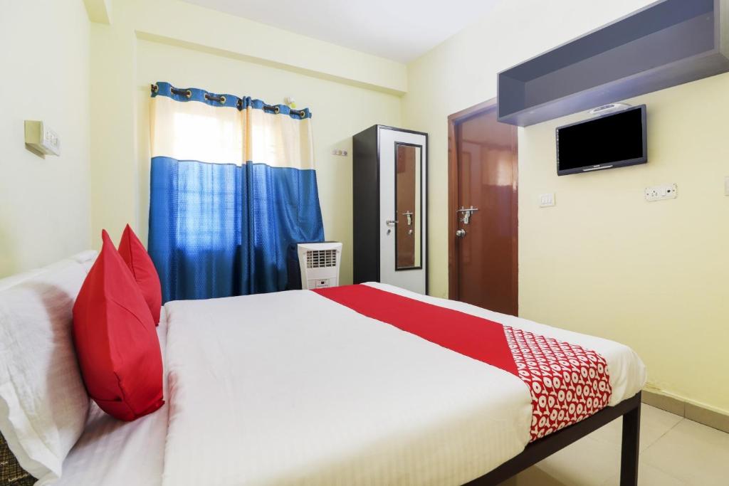 1 dormitorio con 1 cama con almohadas rojas en OYO Ruby Grand Inn, en Kondapur