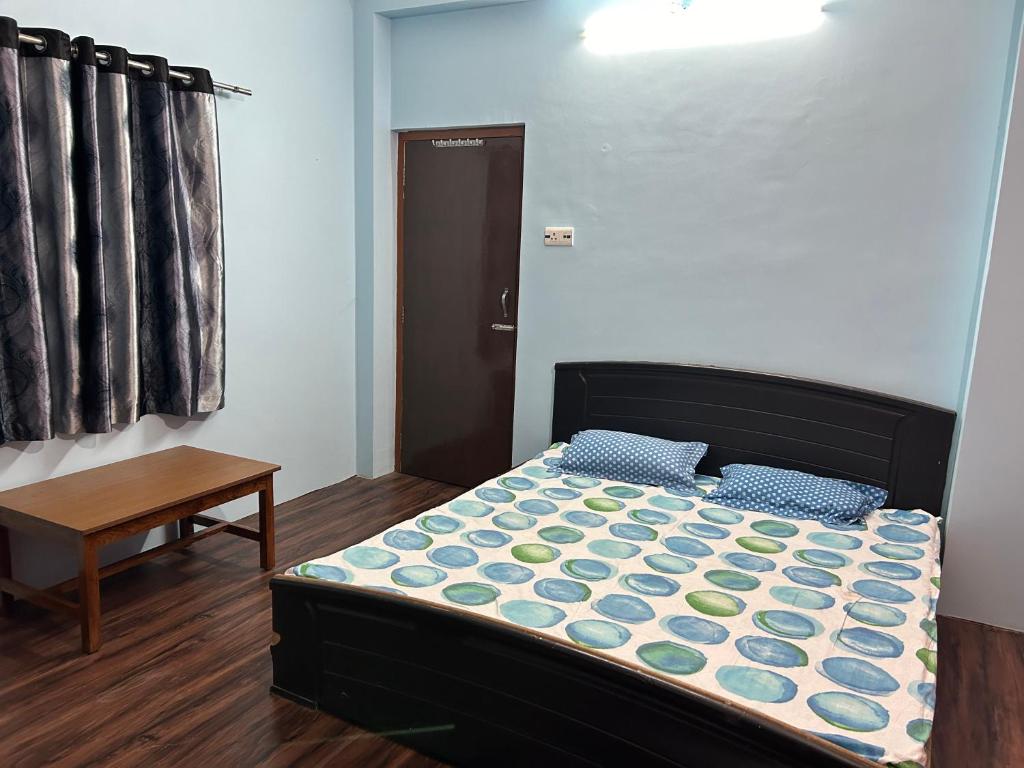 - une petite chambre avec un lit et une table dans l'établissement Sangam palace, à Bettiah