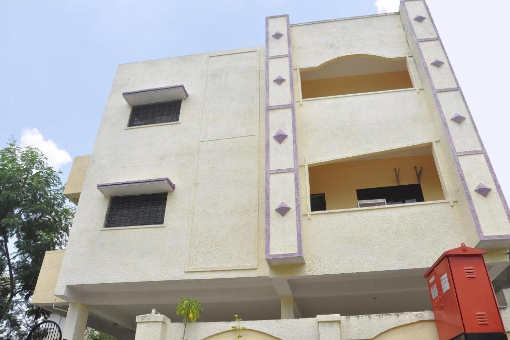 a building with a ladder on the side of it at OYO Infinity Inn in Dhantoli