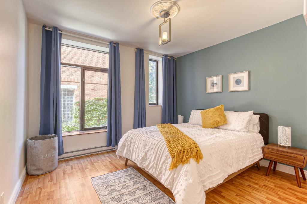 um quarto com paredes azuis e uma cama com um cobertor amarelo em Montreal Boutique Suites em Montréal