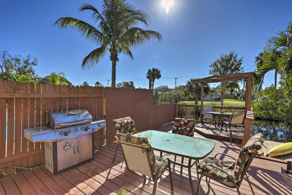 a patio with a grill and a table and chairs at Colorful Canalfront Merritt Island Home Gas Grill in Merritt Island