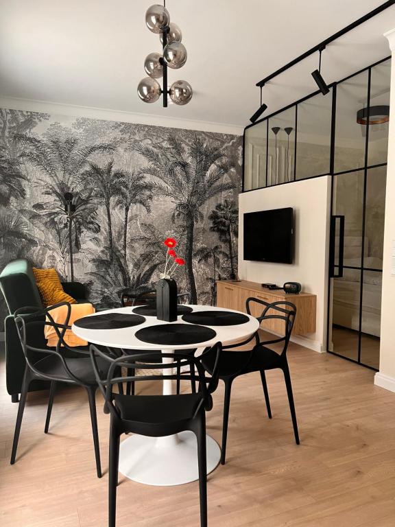 a dining room with a table and chairs and a wall mural at Apartament Old Town Bednarska 22 in Elblag