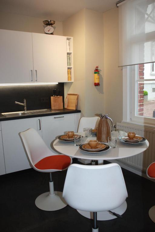 a kitchen with a table and two chairs and a sink at Château La Fontaine - stylish accomodation - green environment in Mons
