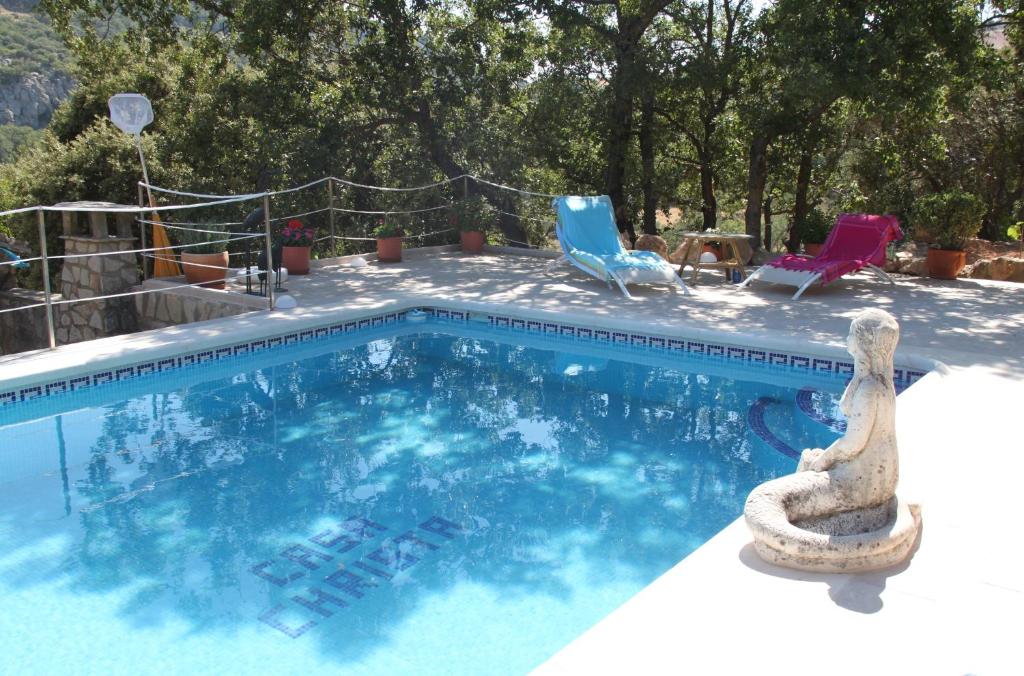 a swimming pool with two lawn chairs and aiki at Casa Christa in Alfarnate