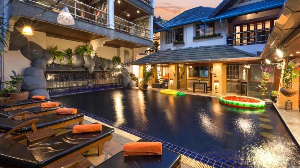 an indoor swimming pool in a house with a swimming pool at Talay Naiharn Hotel in Rawai Beach