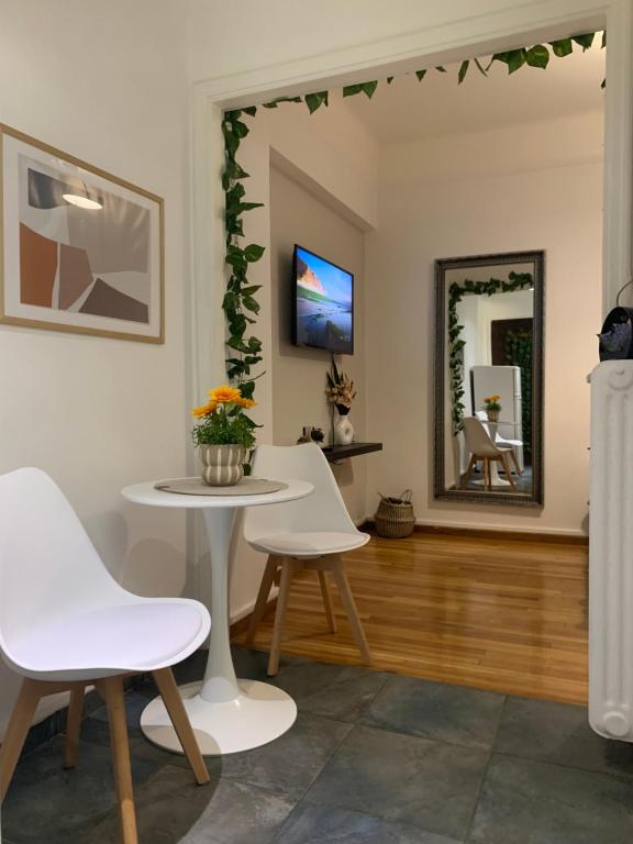 uma sala de estar com uma mesa e cadeiras e um espelho em Charming House in Central Athens em Atenas