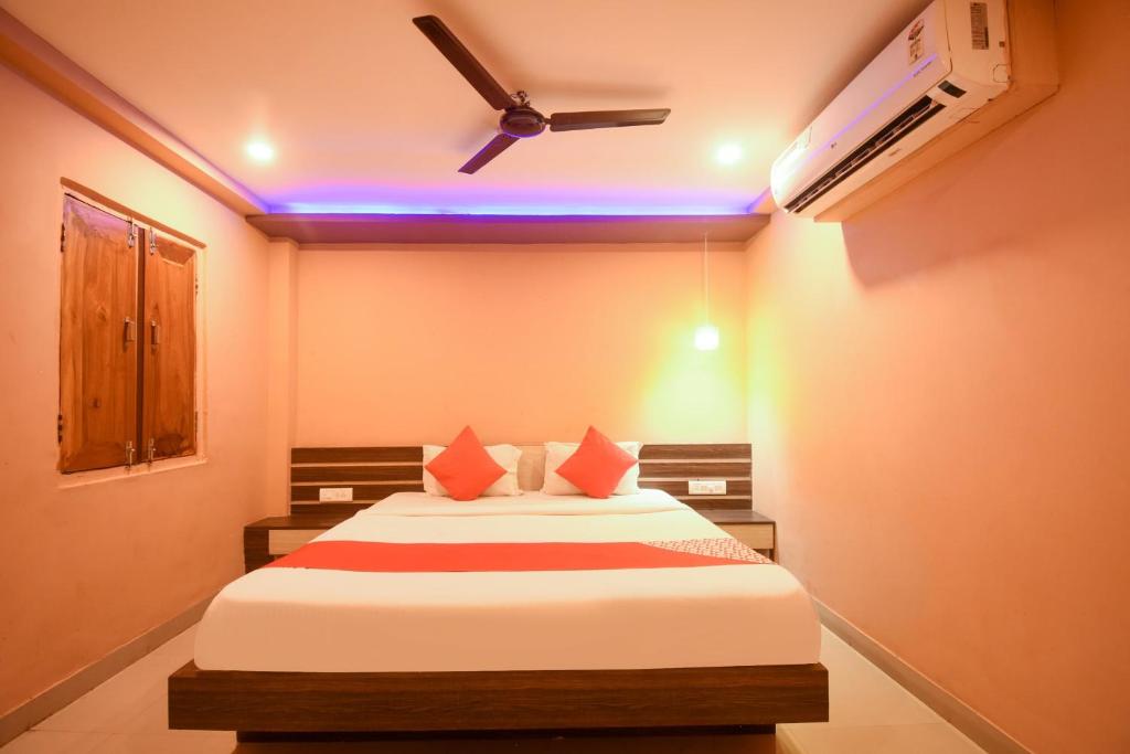 a bedroom with a bed and a ceiling fan at OYO Ssj Residency in Khandagiri