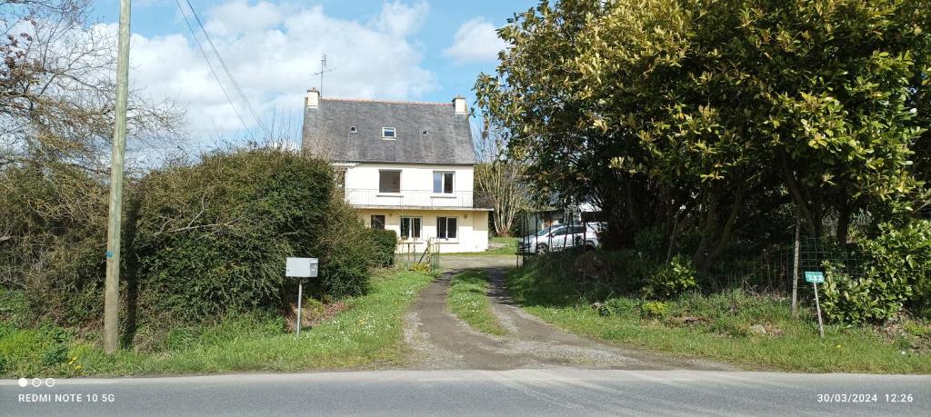 une maison blanche sur le côté d'une route dans l'établissement Saint Brieuc sortie ville Logement dans maison année 1970 disposant de 5 chambres 6 personnes adultes ou enfants, à Saint-Brieuc