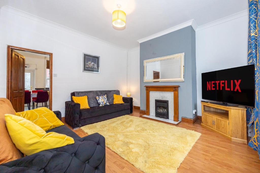 a living room with a couch and a tv at Cosy Two bedroom Terrace Blackburn in Cherry Tree