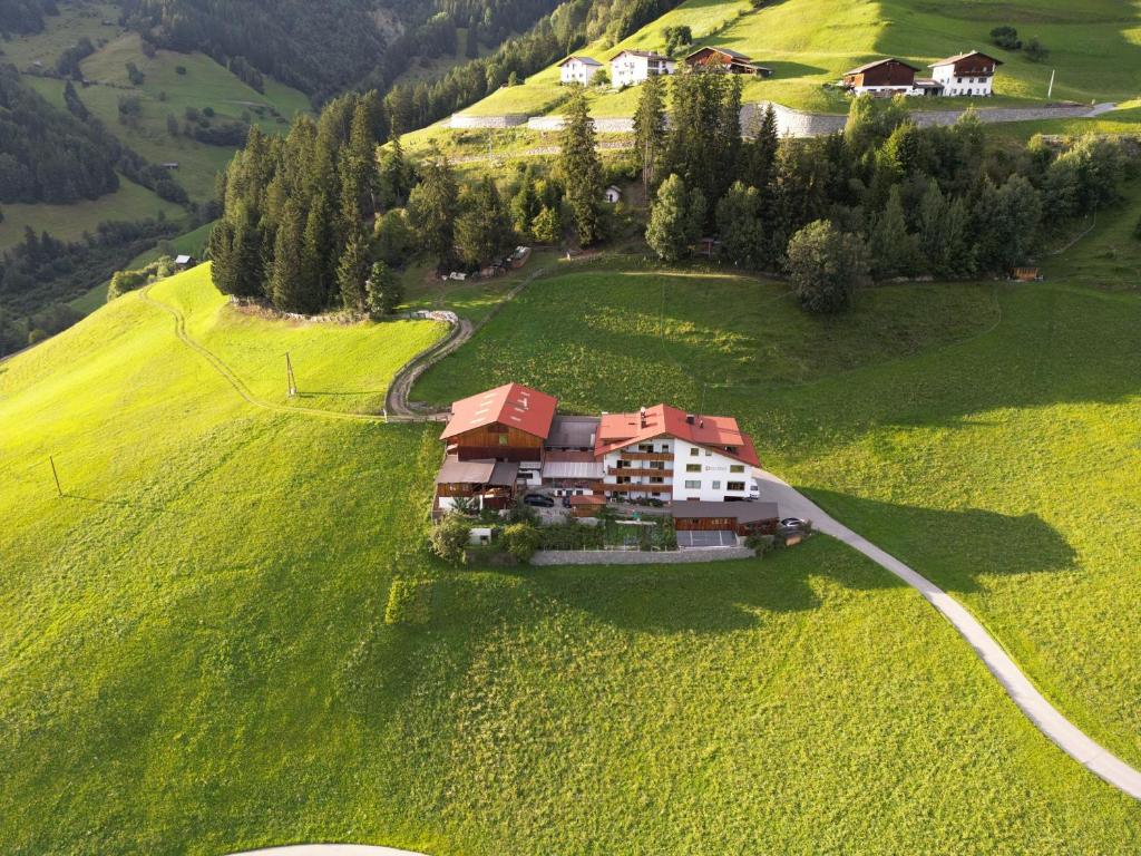 a house on a hill in a green field at Alpenfarm Poschhof in Kaunerberg