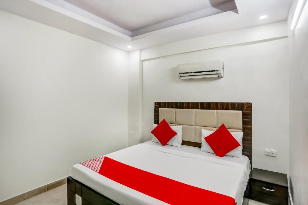 a bedroom with a bed with red pillows at OYO Flagship New Daffodil Inn in Ballabgarh