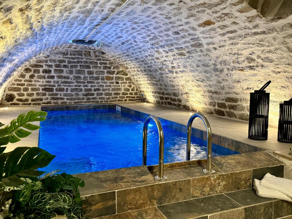 uma piscina numa caverna com água azul em Les Suites de l'Enclos - L'Enclos de l'Evêché em Boulogne-sur-Mer