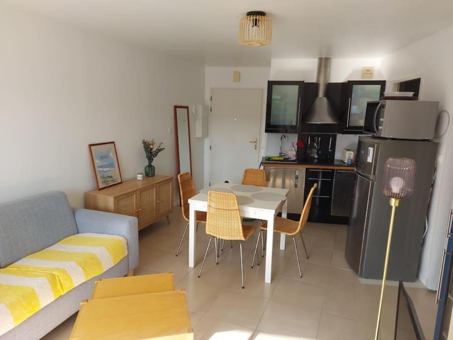 een woonkamer met een bank en een tafel en een keuken bij Appartement Hardelot plage in Neufchâtel-Hardelot