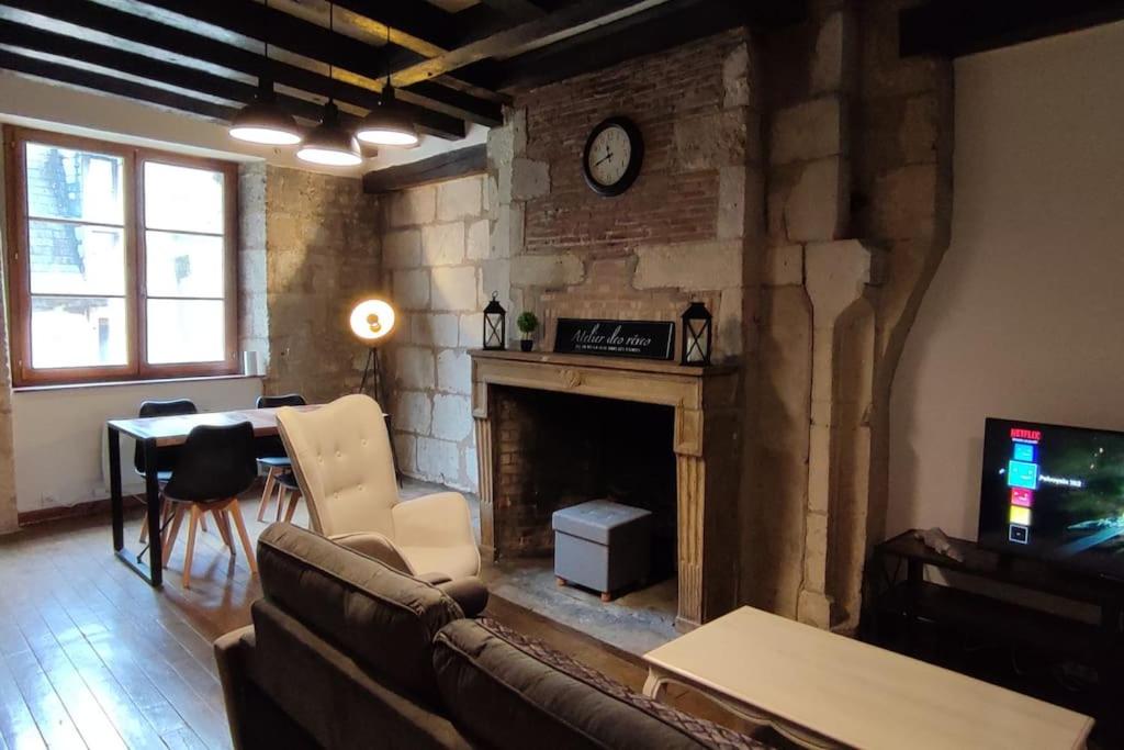 un salon avec un canapé et une cheminée dans l'établissement 102 Duplex Familial de Charme avec Colombages en Immersion Historique et Confort au Cœur de la Ville, à Bourges