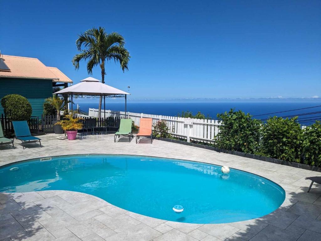 a swimming pool with a view of the ocean at Les Kréol'inns in Saint-Leu