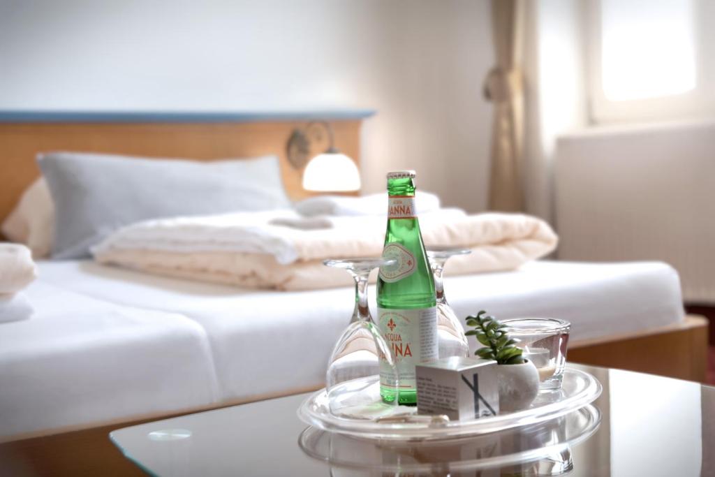 a bottle of beer on a glass table in a bedroom at Hotel Barbarossa in Reichshof 