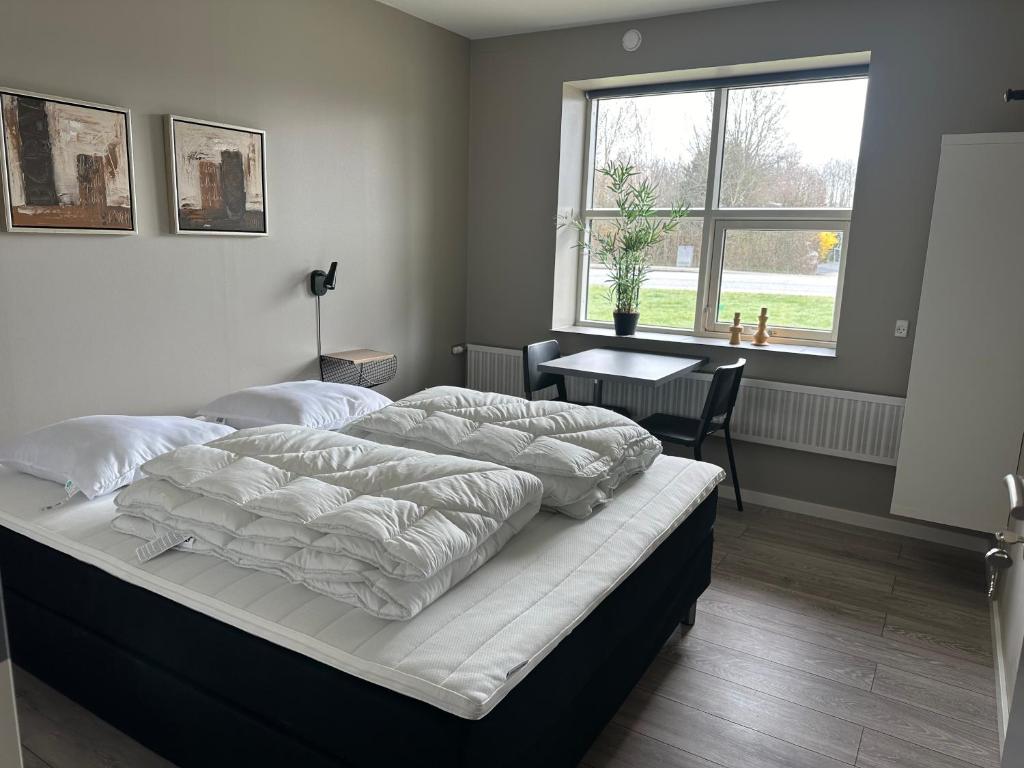 um quarto com 2 camas, uma mesa e uma janela em Det gamle snedkeri em Ribe