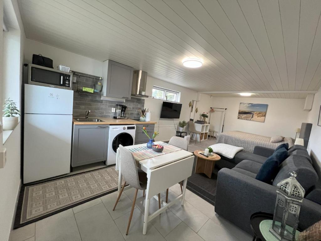 Il comprend un salon avec un canapé bleu et une cuisine. dans l'établissement Vik Österlen, à Simrishamn