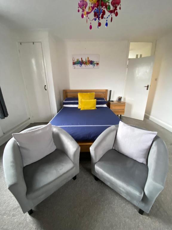 a bedroom with a bed and two chairs at Stylish & Modern Central Studio Apartment Free parking in Southampton