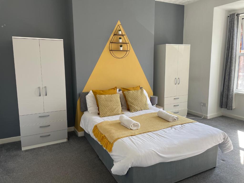 um quarto com uma cama grande e uma cabeceira amarela em Windsor 3 - Perfect Contractor Stay Free Parking 3 bedroom 4 beds Sleeps 6 em Gateshead
