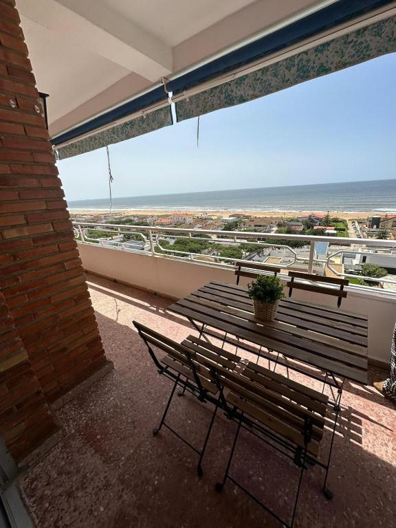 a balcony with a bench and a view of the ocean at Alta Vista Punta Umbría in Punta Umbría