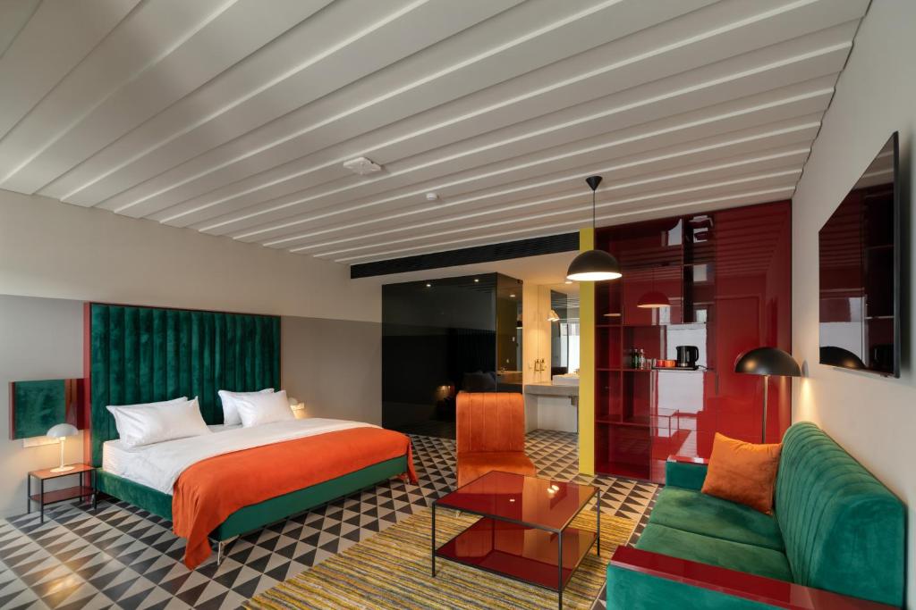 pokój hotelowy z łóżkiem i zieloną kanapą w obiekcie Manifest Restaurant and Hotel Gyumri w mieście Giumri