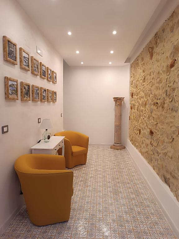 Habitación con 2 sillas, mesa y pared en Real, en Marina di Camerota