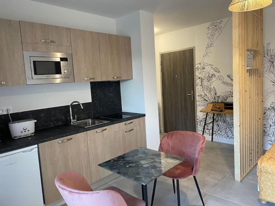une cuisine avec une table, des chaises et un évier dans l'établissement Superbe appartement neuf avec parking sur place, à Corte