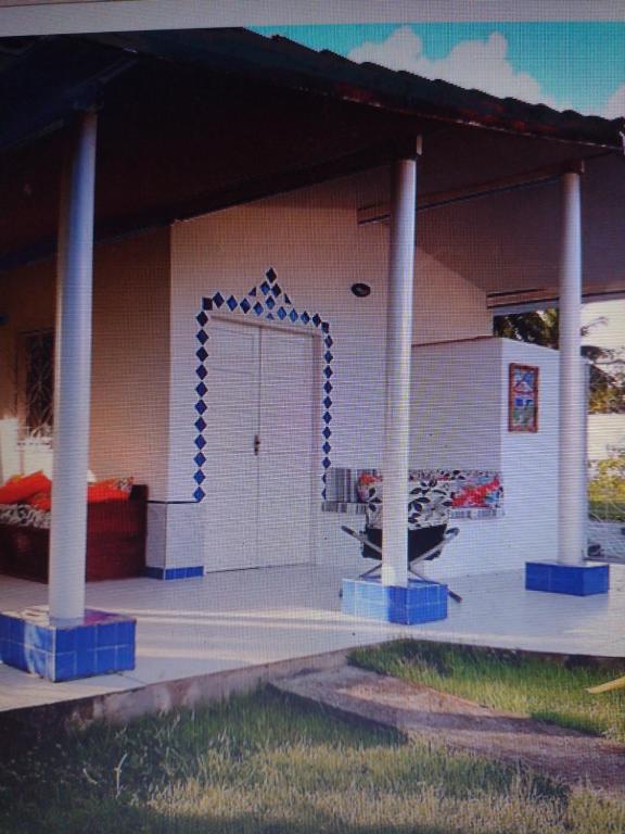 ein Haus mit einer blauen und weißen Eingangstür in der Unterkunft Bangalô Cristal in Itaparica Town