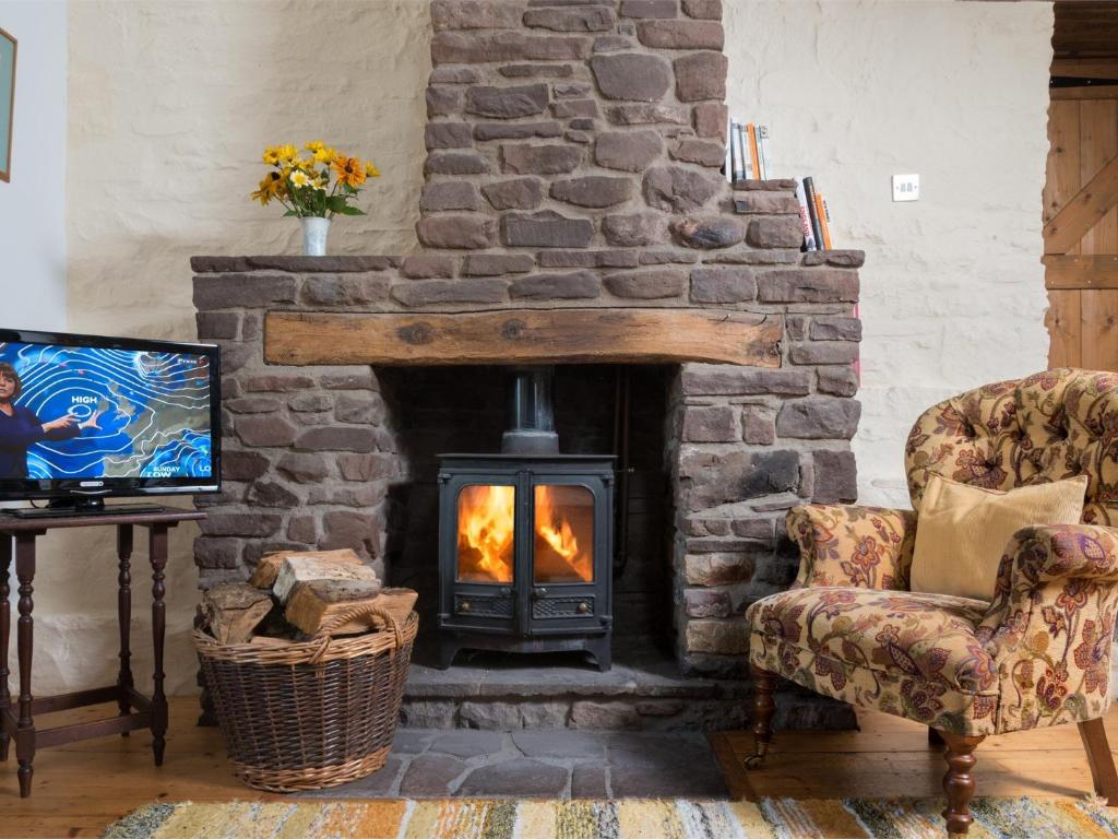 a stone fireplace in a living room with a stove at 1 bed in Llangynidr BN079 in Llangynidr
