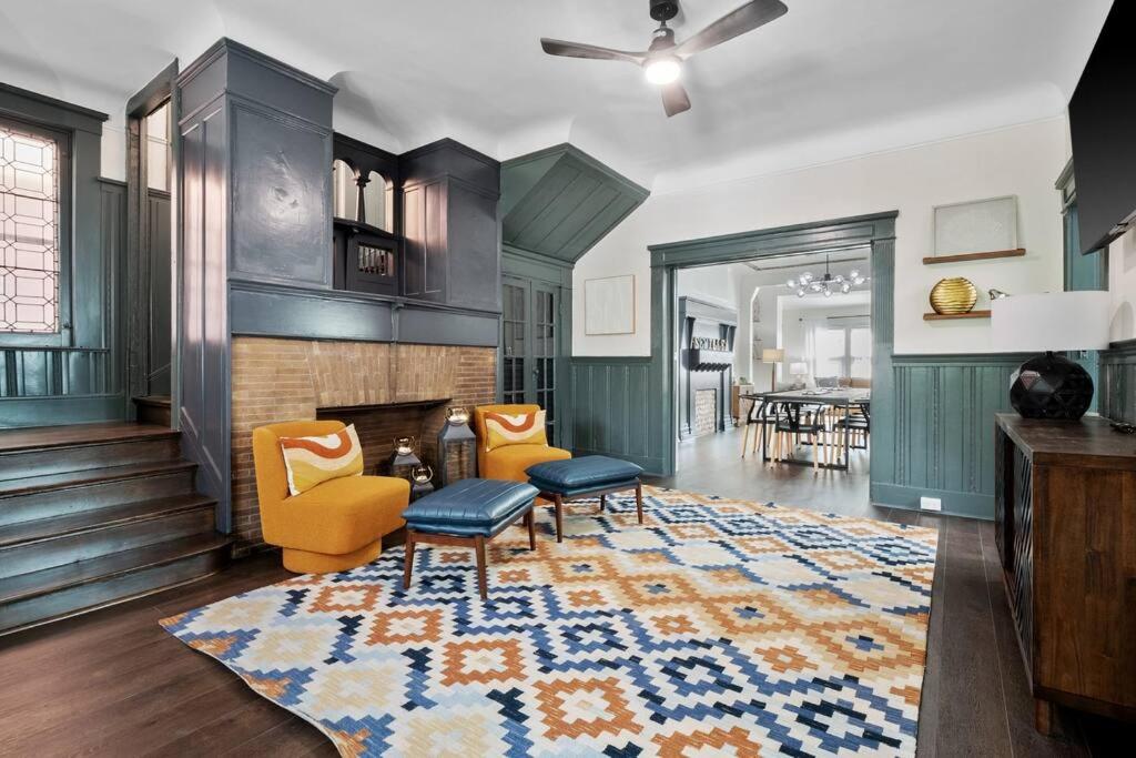 sala de estar con chimenea y sillas amarillas en Luxury Living: Grand 7BR/5BA near Everything, en Tower Grove