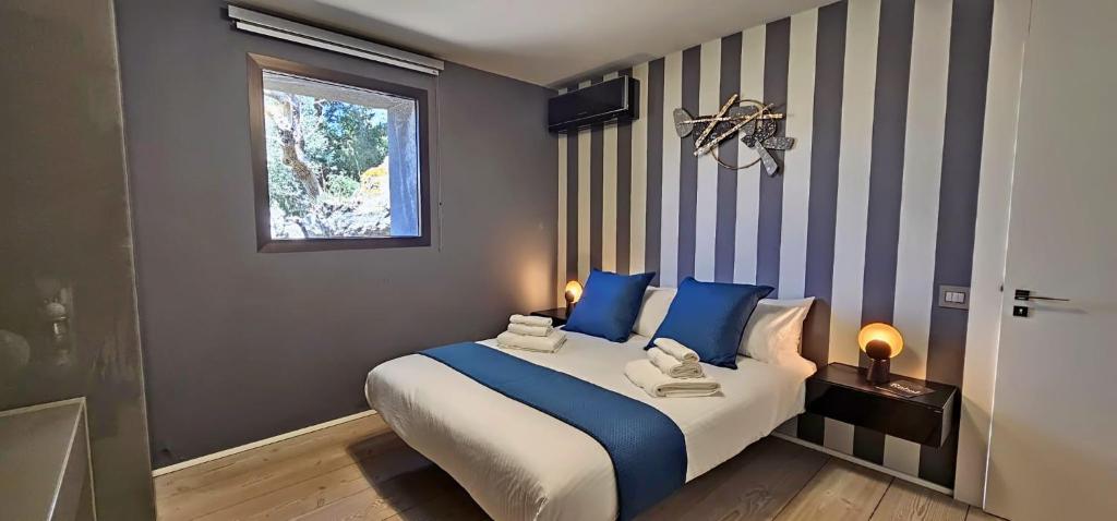 - une chambre avec un lit doté d'oreillers bleus et d'une fenêtre dans l'établissement Rahal - Luxury house with pool - A perferfect getaway, à Catane