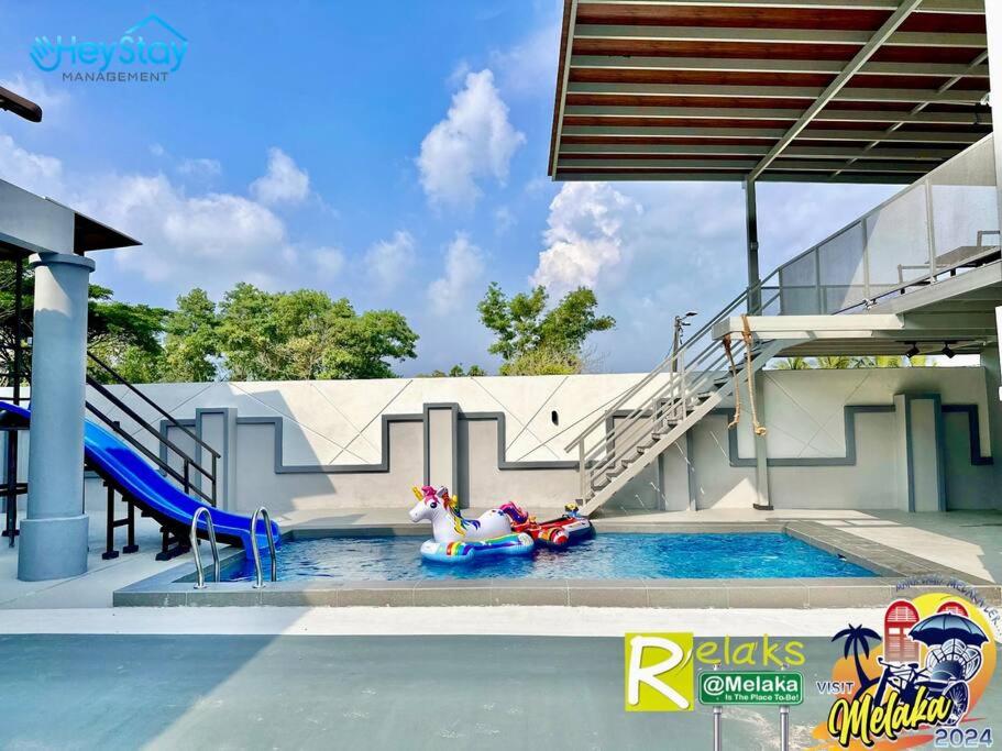 einen Pool mit Rutsche und Pony im Wasser in der Unterkunft Villa 20Pax4B3B PrivatePool /Karaok/Pooltable/BBQ in Malakka