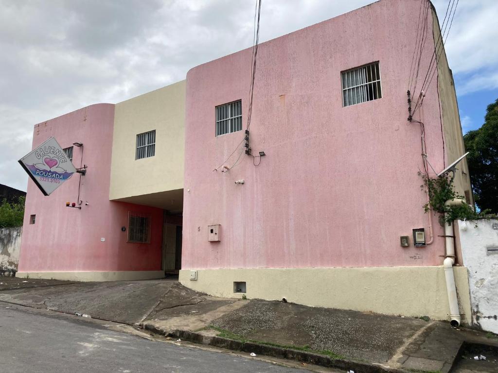 ein rosafarbenes Gebäude an der Straßenseite in der Unterkunft Pousada Caliente in Maceió