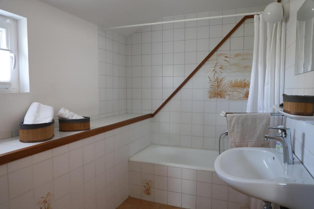 uma casa de banho com um lavatório e uma banheira em Attila Vendégház em Balatonboglár