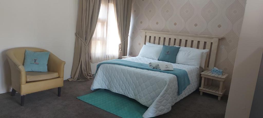 sypialnia z dużym łóżkiem i krzesłem w obiekcie LalaManzi River Lodge w mieście Vanderbijlpark
