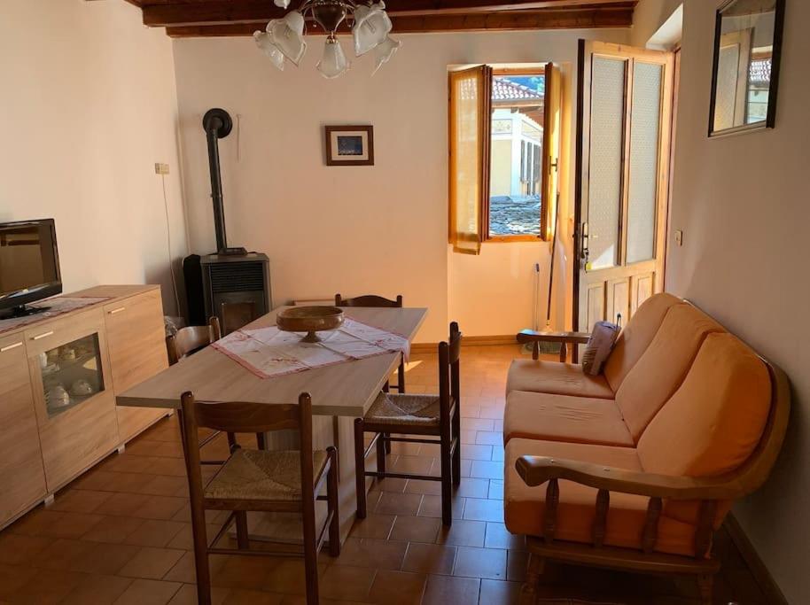 een woonkamer met een tafel en een bank bij Casa vacanza a Forno di Valstrona con terrazzo e giardino in Strona
