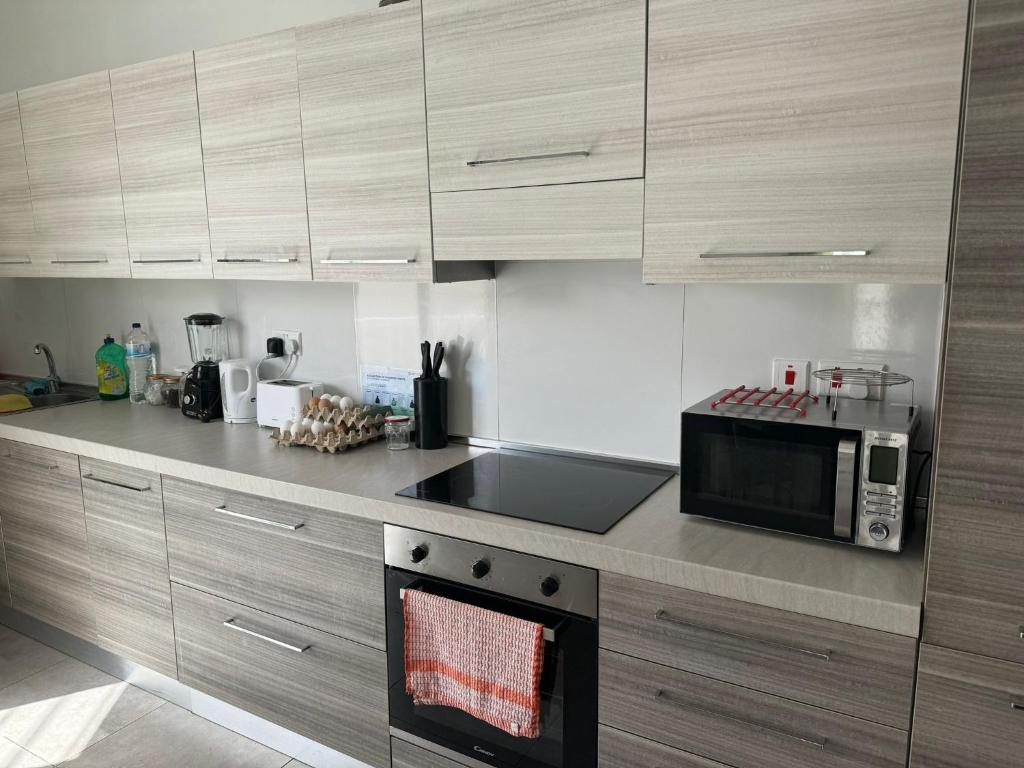 a kitchen with a microwave and a stove top oven at Private Room in Beatifull Aparment in Birkirkara