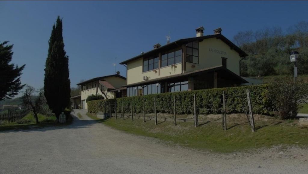 Agriturismo La Scalera في لوناتو: منزل كبير أمامه سور