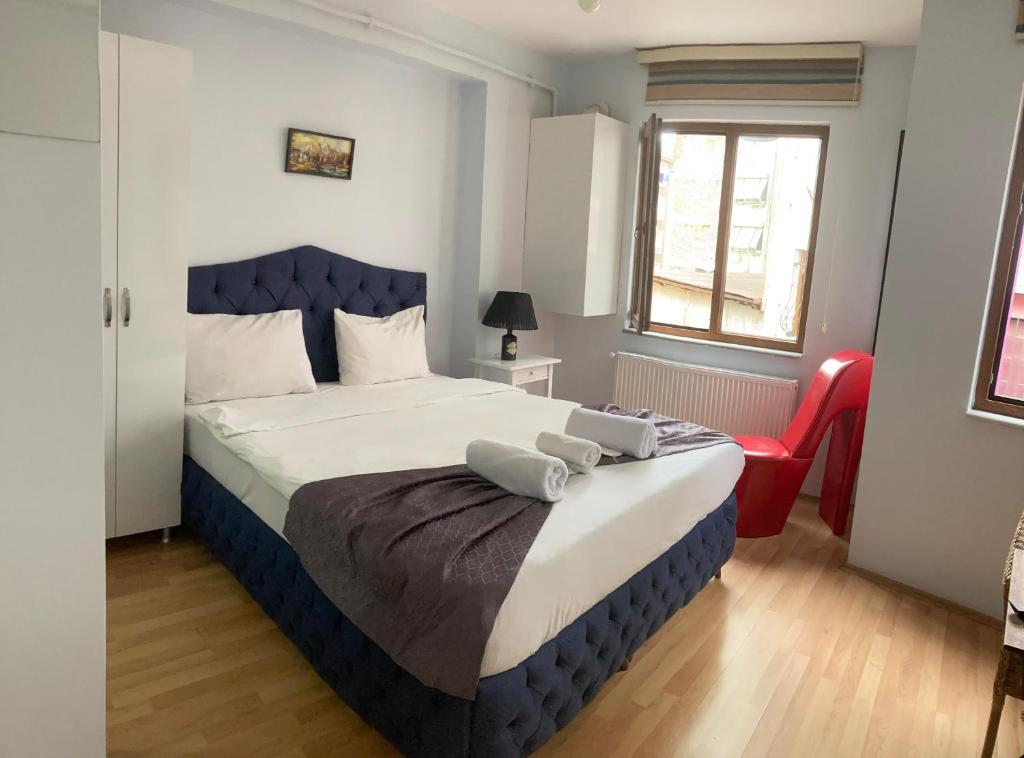 um quarto com uma cama azul e branca e uma cadeira vermelha em centre suites em Istambul