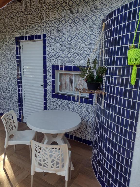 a table and chairs in a room with blue tiles at Casa Girassol in Itaparica