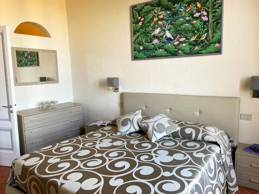 シエナにあるAppartamento Mimosaのベッドルーム1室(ベッド1台付)が備わります。壁には絵画が飾られています。